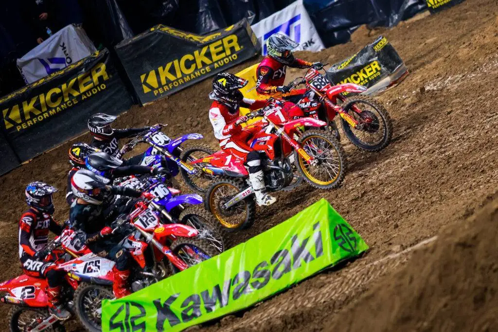 Riders bunching up coming out of a corner during an AMA Arenacross race.
